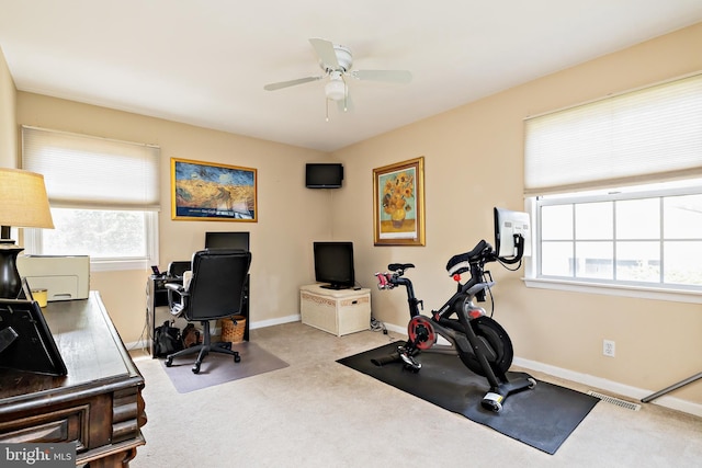 exercise room featuring carpet floors, ceiling fan, visible vents, and a healthy amount of sunlight