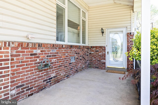 view of exterior entry featuring brick siding