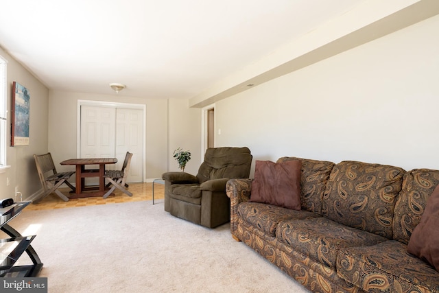 carpeted living room featuring baseboards