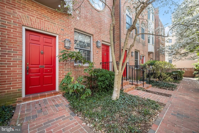 view of exterior entry featuring brick siding