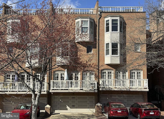 view of front facade featuring a garage, driveway, and brick siding