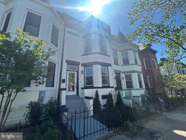 townhome / multi-family property featuring a fenced front yard and stucco siding