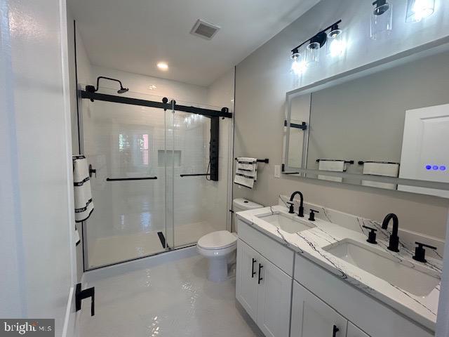 bathroom with toilet, visible vents, a sink, and a stall shower