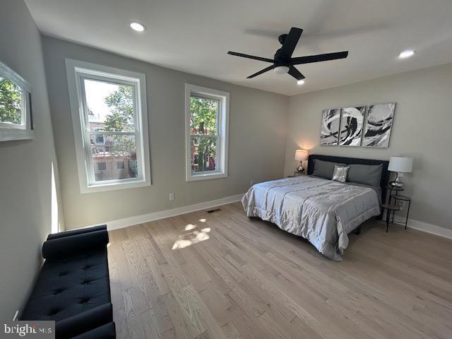 bedroom with recessed lighting, baseboards, multiple windows, and wood finished floors