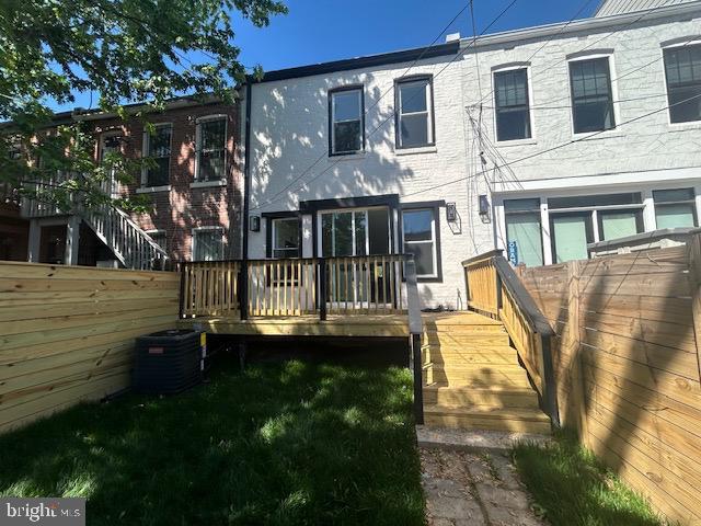 rear view of house with central air condition unit, fence, and a deck