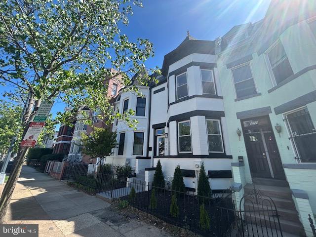 townhome / multi-family property with a fenced front yard and stucco siding