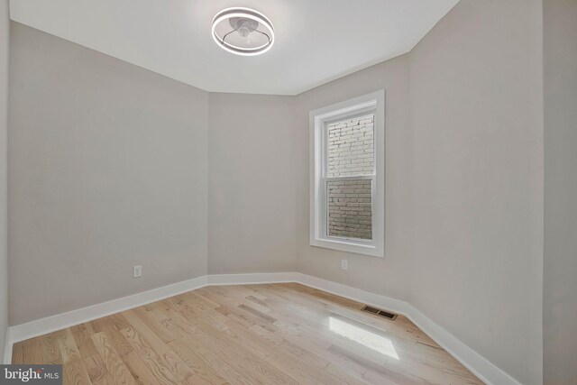 unfurnished room with baseboards, visible vents, and light wood-style floors
