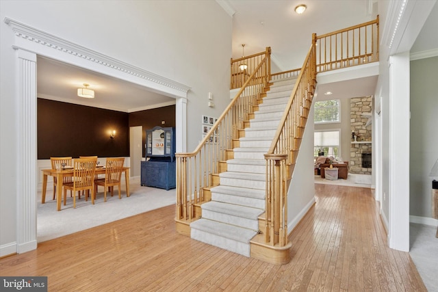 1 Arbor Lea Cir, Doylestown, PA 18901 - stairs with wood-type flooring, a stone fireplace, a towering ceiling, ornamental molding, and baseboards
