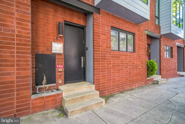 doorway to property featuring brick siding