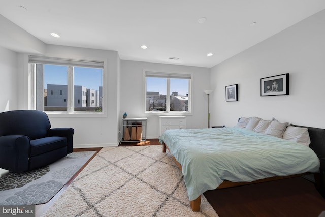 bedroom featuring baseboards, recessed lighting, wood finished floors, and visible vents