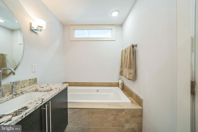 full bathroom featuring a garden tub and vanity