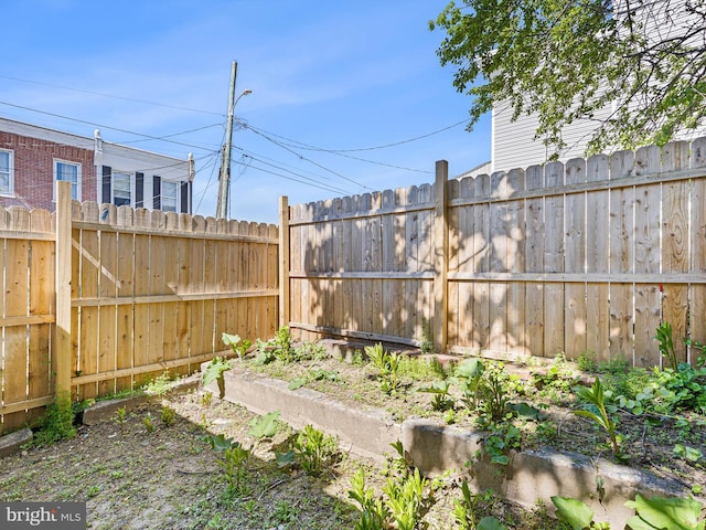 view of yard featuring fence and a vegetable garden