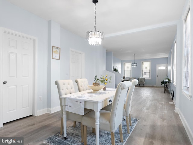 dining room featuring baseboards, a chandelier, and wood finished floors