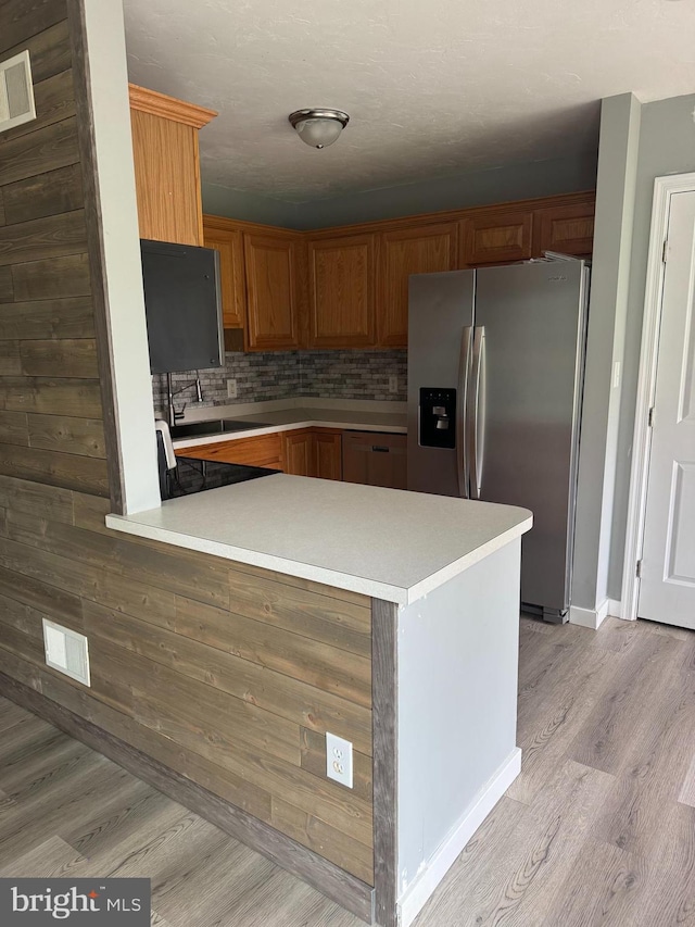 661 Hartman Ave, Hanover, PA 17331 - kitchen with decorative backsplash, stainless steel refrigerator with ice dispenser, light countertops, light wood finished floors, and a peninsula