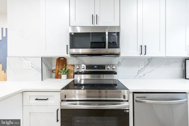 2074 E Birch St, Philadelphia, PA 19134 - kitchen with light countertops, decorative backsplash, white cabinets, and stainless steel appliances