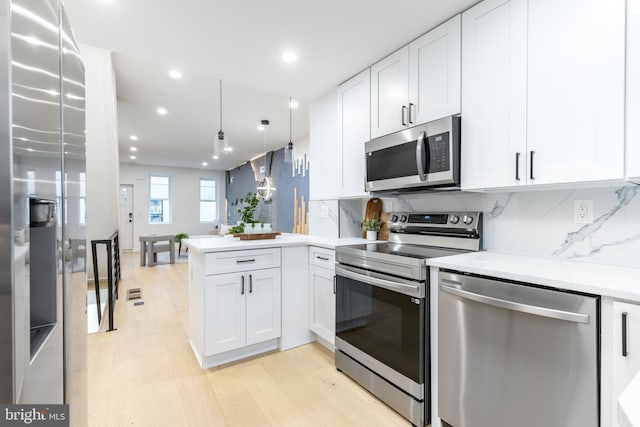 2074 E Birch St, Philadelphia, PA 19134 - kitchen with appliances with stainless steel finishes, white cabinets, a peninsula, recessed lighting, and light wood-style flooring