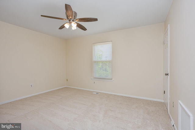 carpeted spare room featuring a ceiling fan, baseboards, and visible vents