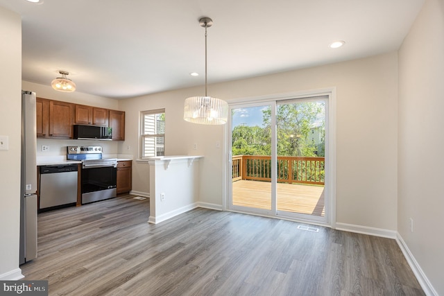 kitchen with visible vents, light wood-type flooring, light countertops, baseboards, and stainless steel appliances