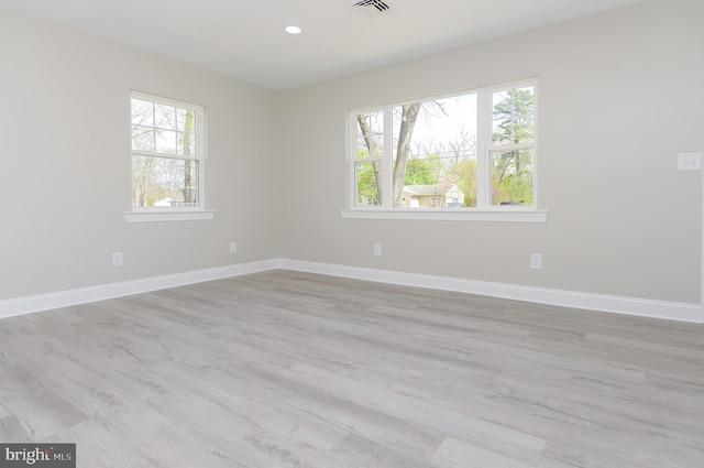 unfurnished room with light wood-style floors, baseboards, plenty of natural light, and recessed lighting