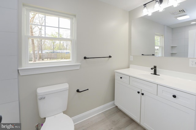 bathroom with visible vents, wood finished floors, baseboards, vanity, and toilet