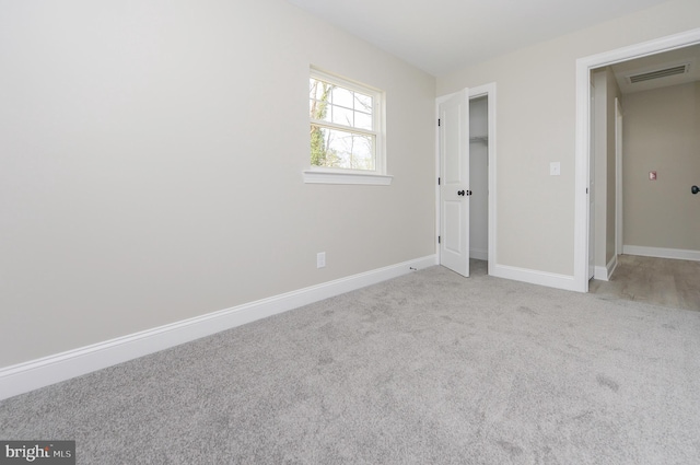 unfurnished bedroom with carpet floors, baseboards, and visible vents