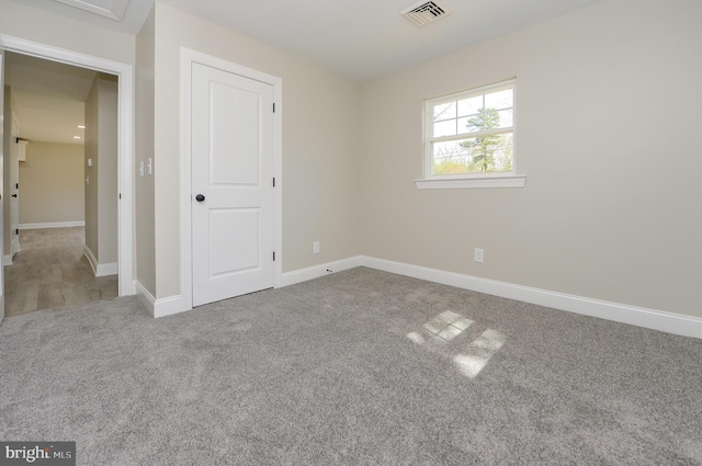 unfurnished bedroom with carpet floors, baseboards, and visible vents