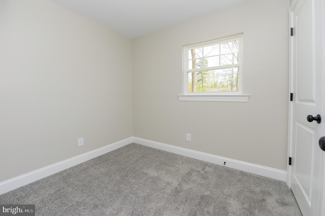 empty room featuring carpet flooring and baseboards