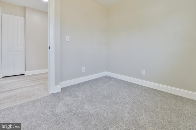 carpeted empty room featuring baseboards