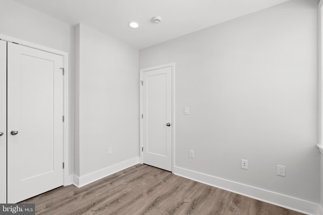 unfurnished bedroom with baseboards, recessed lighting, and wood finished floors