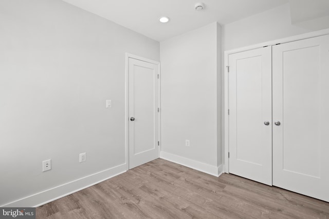 unfurnished bedroom with baseboards, recessed lighting, and wood finished floors
