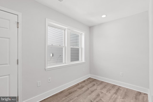 empty room featuring baseboards, recessed lighting, and light wood-style flooring
