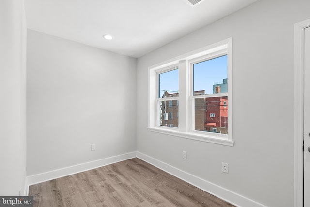 unfurnished room with baseboards, recessed lighting, and wood finished floors