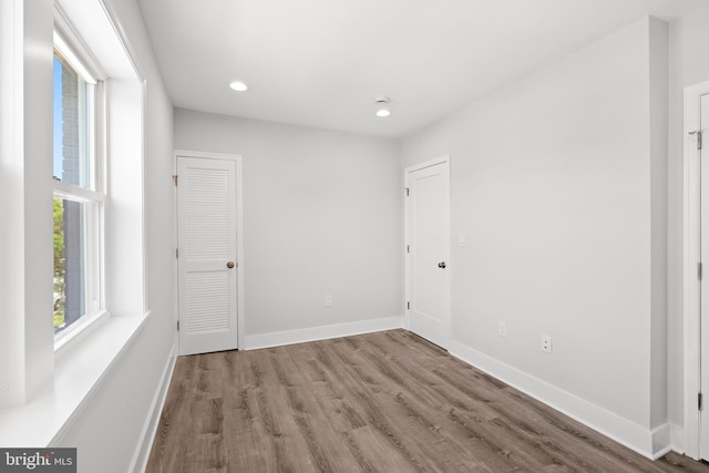 unfurnished bedroom with recessed lighting, baseboards, and wood finished floors