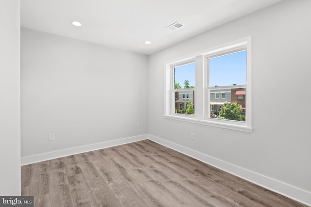 spare room featuring visible vents, recessed lighting, baseboards, and wood finished floors