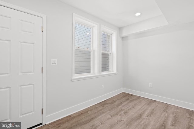 empty room with baseboards, recessed lighting, and light wood finished floors