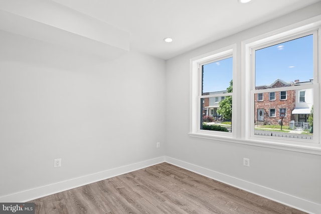 unfurnished room with baseboards, recessed lighting, and wood finished floors