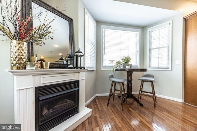 dining area with wood-type flooring, baseboards, and a fireplace
