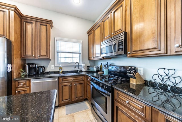 kitchen featuring a sink, appliances with stainless steel finishes, and brown cabinetry