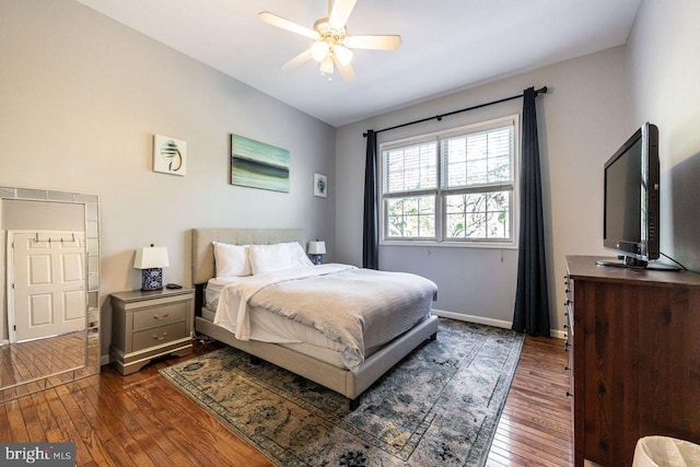 bedroom featuring baseboards, ceiling fan, and dark wood finished floors