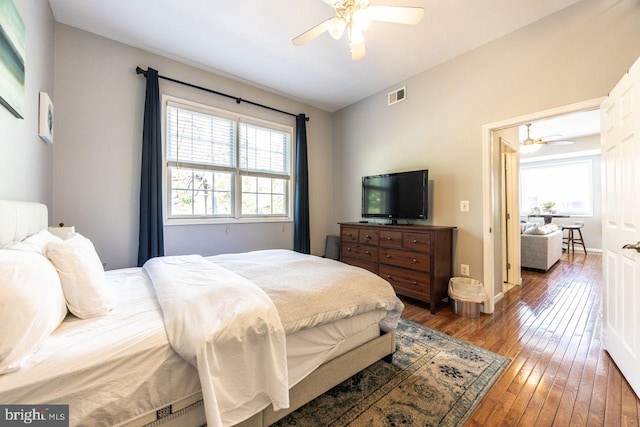 bedroom featuring visible vents, ceiling fan, multiple windows, and hardwood / wood-style flooring
