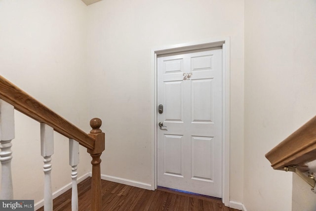 entryway featuring baseboards and dark wood-type flooring