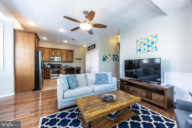 living room with light wood-type flooring, recessed lighting, ceiling fan, and visible vents