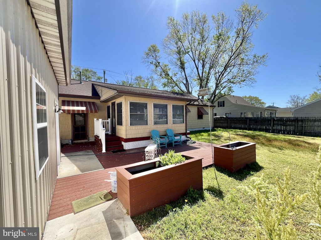 view of yard featuring fence, a vegetable garden, and a deck