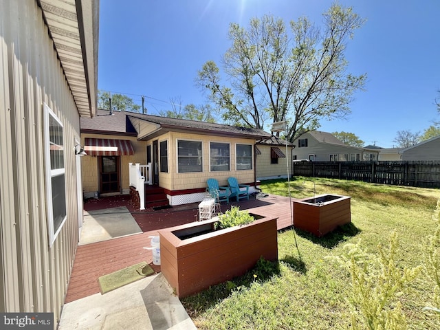 view of yard featuring fence, a vegetable garden, and a deck
