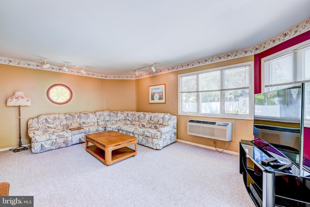 living room with a healthy amount of sunlight, track lighting, an AC wall unit, and carpet floors