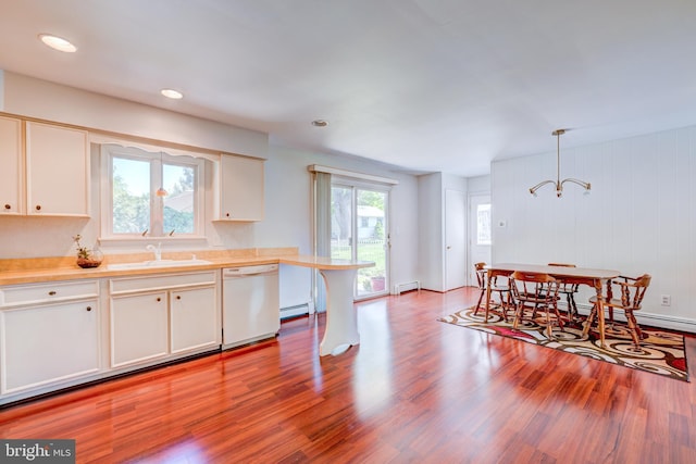 kitchen with light countertops, a baseboard radiator, a sink, and dishwasher