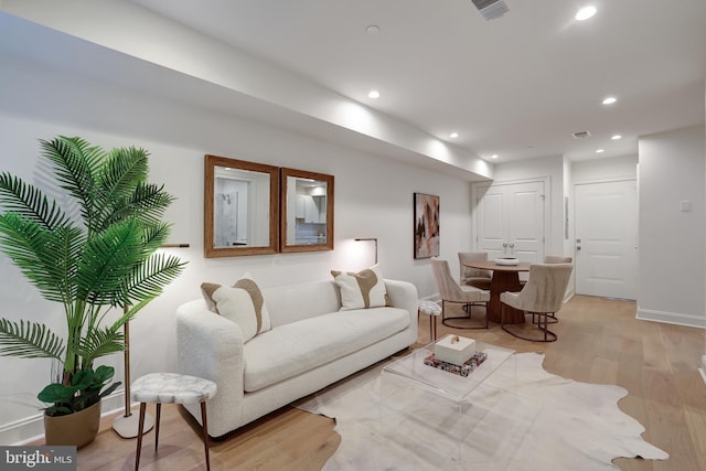 living room with recessed lighting, light wood-style flooring, baseboards, and visible vents
