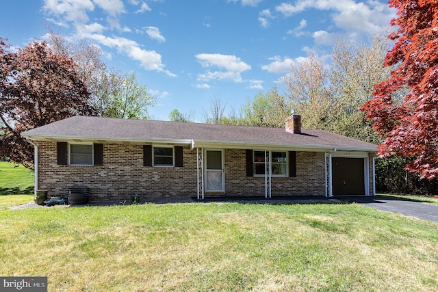 view of front of house with driveway, a chimney, brick siding, a front lawn, and an attached garage