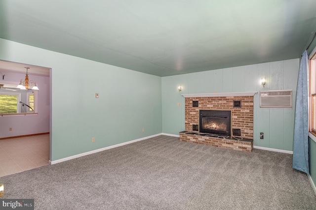 unfurnished living room with an AC wall unit, carpet, a brick fireplace, and baseboards