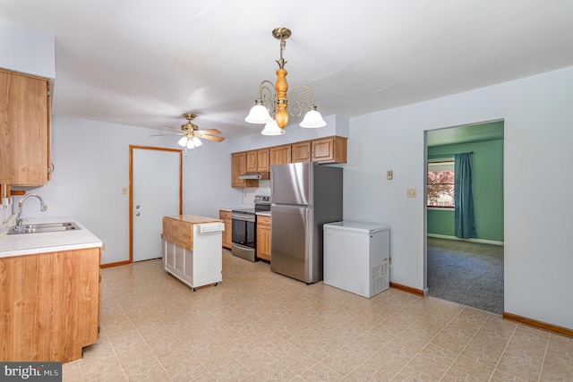 kitchen featuring baseboards, light countertops, under cabinet range hood, a sink, and stainless steel appliances